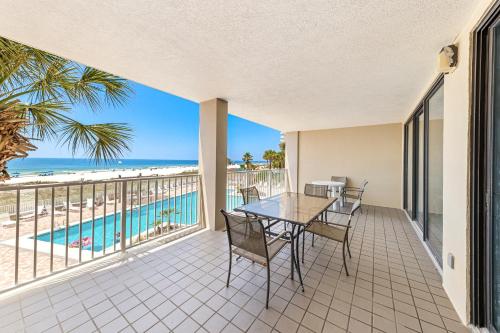 a balcony with a table and chairs and a view of the beach at White Caps 204 in Orange Beach