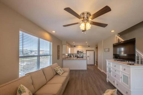 a living room with a couch and a ceiling fan at The Herron, Sleep 20, Walk beach in Gulf Shores