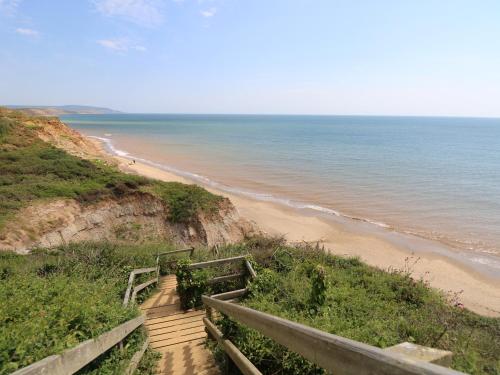 a staircase leading down to a beach with the ocean at The Stables in Newport