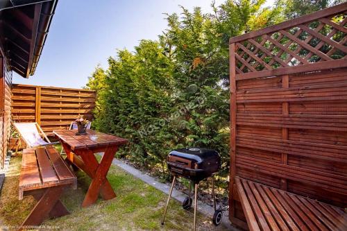- un barbecue et une table de pique-nique à côté d'une clôture dans l'établissement Domek letniskowy, à Władysławowo