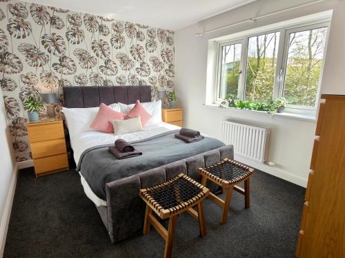 a bedroom with a bed and two chairs in it at Sanderson House in Cleator Moor