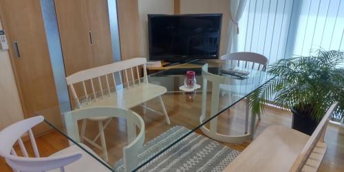 - un salon avec une table et des chaises en verre dans l'établissement Guest Room安曇野2466, à Hitoichiba