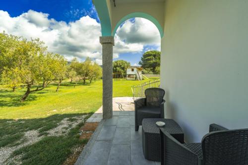 a patio with chairs and a view of a field at Borgo Albador Rooms in Posada