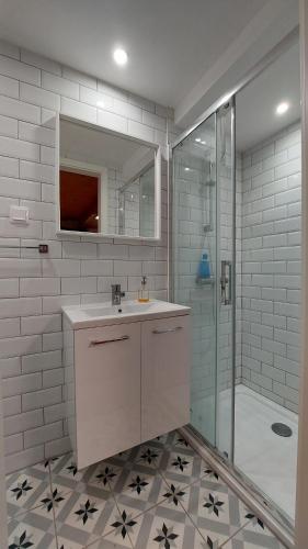 a white bathroom with a sink and a shower at Das Eckhaus in Murau
