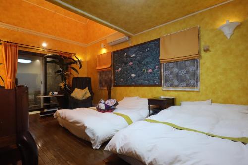 1 dormitorio con 2 camas y un cuadro en la pared en 1日1組限定Villa Dazaifu 露天風呂付1棟貸し en Dazaifu