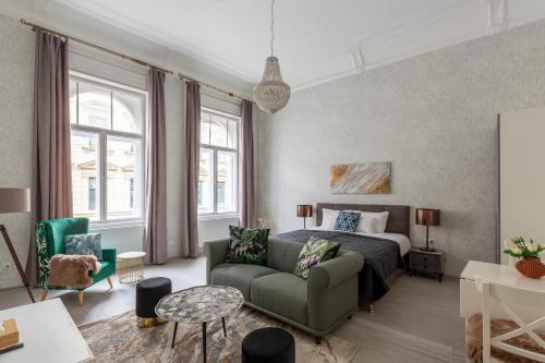 a bedroom with a bed and a green couch at LH Gallery Apartments in Budapest