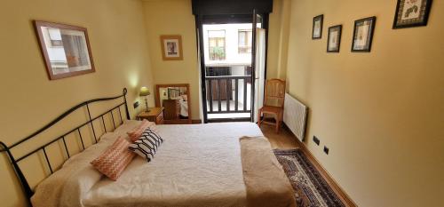 Un dormitorio con una cama con almohadas. en Raitán 2 - Apartamento con piscina para 4 pax, en Colunga