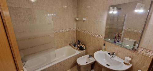 y baño con lavabo, bañera y aseo. en Raitán 2 - Apartamento con piscina para 4 pax, en Colunga