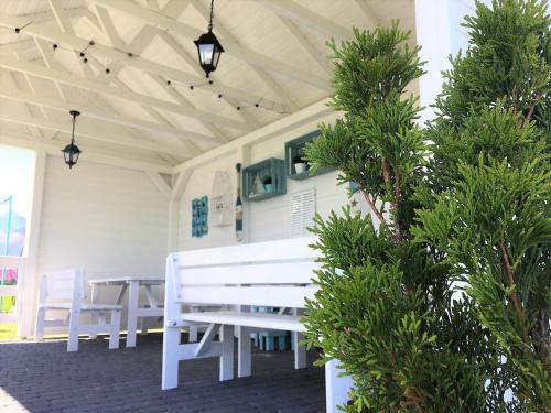 a white bench sitting inside of a building with trees at Morska Mila in Kopań