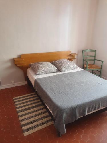 Schlafzimmer mit einem Bett mit einem Kopfteil aus Holz in der Unterkunft La Baieta in Moulinet