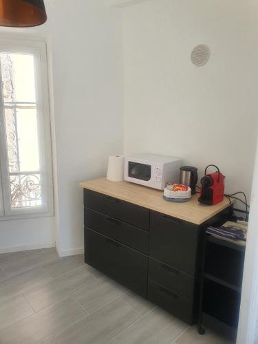 a kitchen with a counter with a microwave on it at Chambre bleue La Baieta in Moulinet