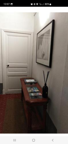 a room with a table with a picture on the wall at Chambre bleue La Baieta in Moulinet