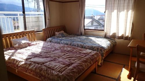 a bedroom with two beds in front of a window at 星の宿　Hoshi no Yado in Iiyama