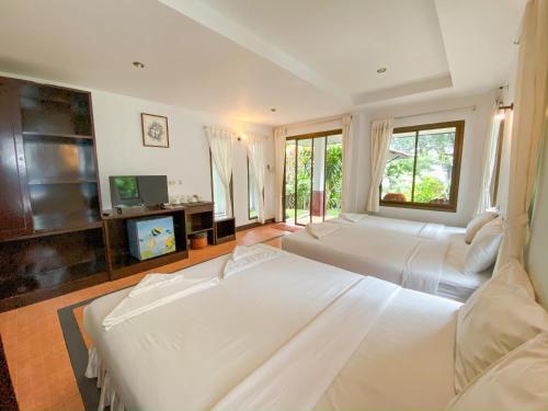 a bedroom with two white beds and a tv at Samui Honey Backpacker Bungalow in Choeng Mon Beach