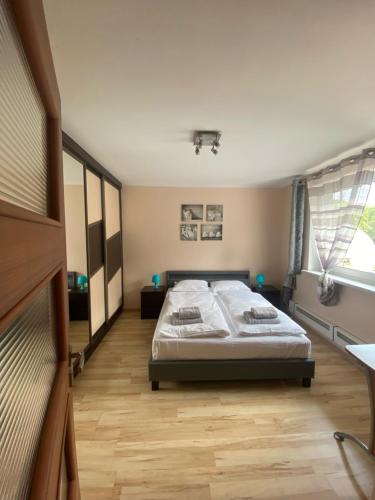 een slaapkamer met een bed en een houten vloer bij Apartament Diego in Polanica-Zdrój