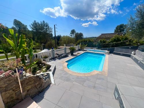 a swimming pool in a yard with a patio at HAUT DE VILLA AVEC PISCINE privative ET APPARTEMENT REZ DE CHAUSSEE in Le Tignet