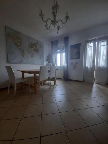 une salle à manger avec une table et des chaises blanches dans l'établissement Casa vista lago, à Toscolano Maderno