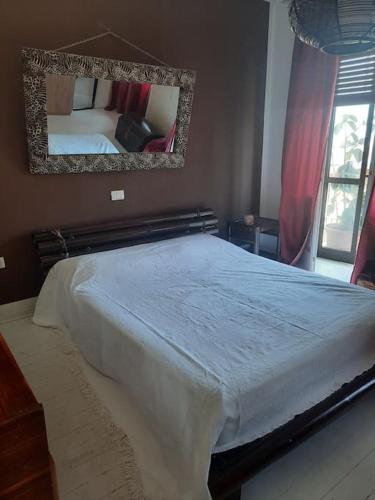 - une chambre avec un lit et un miroir mural dans l'établissement Casa vista lago, à Toscolano Maderno