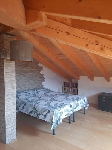 - une chambre avec un lit dans une pièce dotée de plafonds en bois dans l'établissement Casa vista lago, à Toscolano Maderno