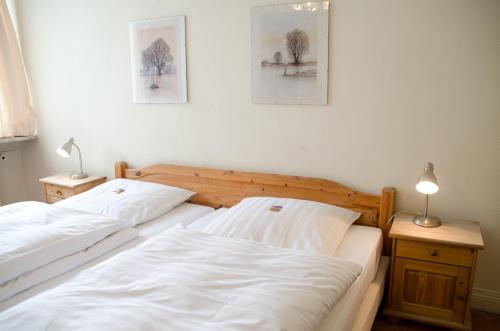 two white beds in a room with two lamps and two beds sidx sidx sidx at Niemann's Gasthof in Reinbek
