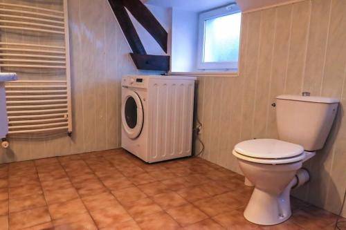 ein Badezimmer mit einem WC, einer Waschmaschine und einem Trockner in der Unterkunft Le Saint-Cyr, Centre-ville, Cosy, Spacieux in Issoudun