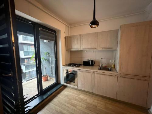 uma cozinha com armários de madeira e uma grande janela em Apart Mihai Viteazu Residence em Braşov