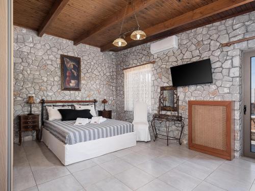 a bedroom with a bed and a stone wall at Alkistis Sweet Homes in Stavros