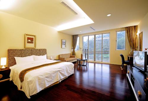 a hotel room with a bed and a television at Sun Moon Lake Karuizawa Villa in Yuchi