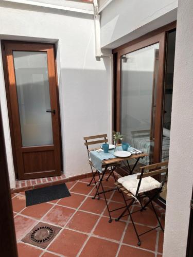 a patio with a table and chairs and a door at Apartamento vacacional Marbella centro La casita de la portera in Marbella