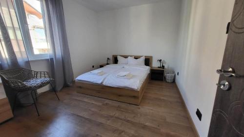 a small bedroom with a bed and a chair at Q Аpartment in Tsarevo