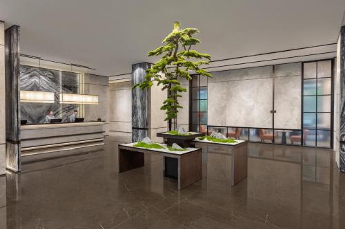 a lobby with two tables with plants on them at Citadines Qingshanhu Hangzhou in Hangzhou