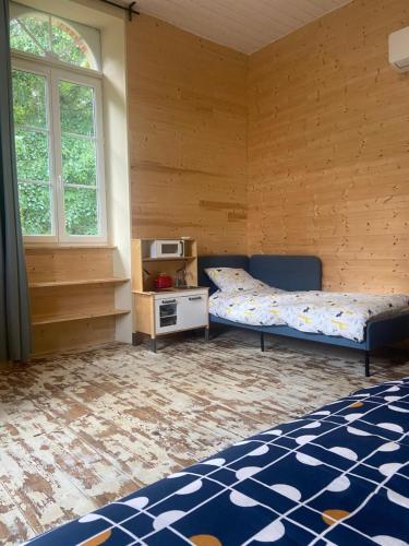 - une chambre avec un lit et une table avec un four micro-ondes dans l'établissement La demeure landaise, à Linxe