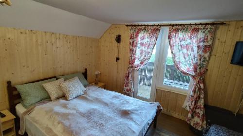 1 dormitorio con cama y ventana en Cabana 2 Râuri, en Bratca