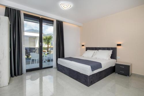 a bedroom with a large bed and a balcony at Kataleya Poolside Suites in Skala Potamias