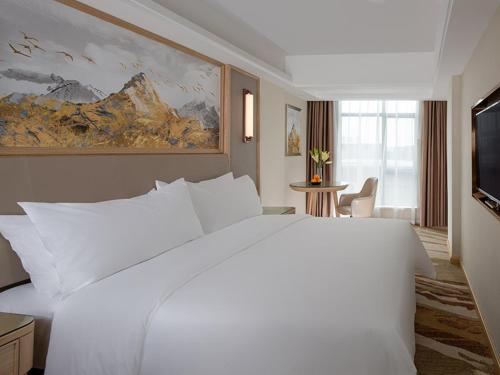 a large white bed in a hotel room at Vienna International Hotel South Gate of Shenzhen International Convention and Exhibition Center in Bao'an