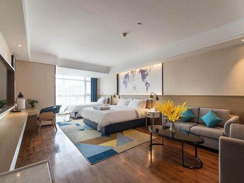ein Hotelzimmer mit einem Bett und einem Sofa in der Unterkunft Kyriad Marvelous Hotel Kunming High-Tech Zone Wuyue Plaza in Kunming