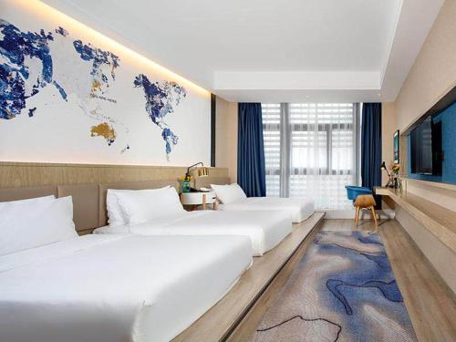 a hotel room with two beds and a map of the world at Kyriad Marvelous Hotel Chongqing North Railway Station in Chongqing