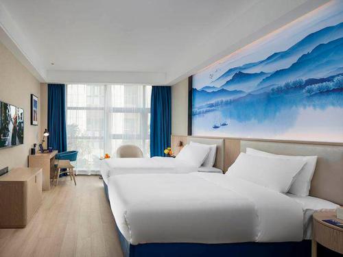 a hotel room with two beds and a large window at Kyriad Hotel Luoyang Longmen Railway Station in Luoyang