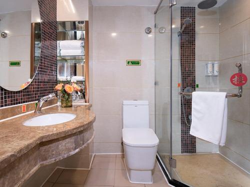 y baño con aseo, lavabo y ducha. en Vienna SanHao Hotels Yichun Gao'an Avenue, en Gao'an