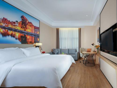 a hotel room with a large bed and a television at Vienna International Hotel Chongqing North Station in Chongqing