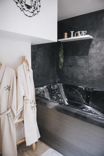 une salle de bain avec un lavabo et une baignoire dans l'établissement appartement 2 pièces jacuzzi, à Brioude