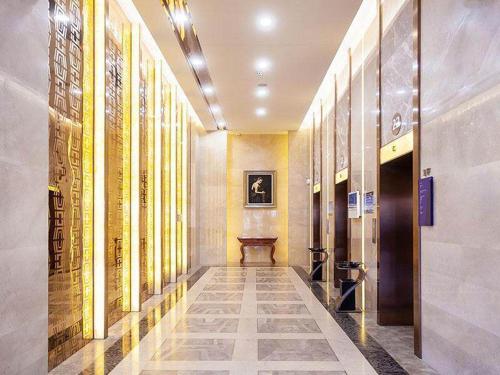 a hallway of a building with a table in it at Kyriad Marvelous Hotel Weihai Railway Station in Weihai