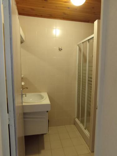 une salle de bain blanche avec un lavabo et une douche dans l'établissement Jura , région des lacs, à Monnet-la-Ville