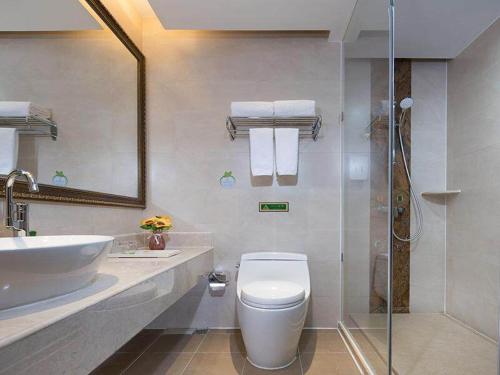 uma casa de banho com um WC, um lavatório e um chuveiro em Vienna Hotel Huaidong Road Yuncheng em Yuncheng
