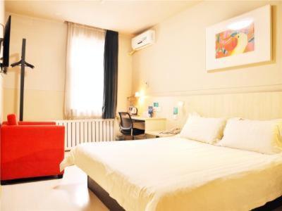 1 dormitorio con 1 cama blanca y 1 silla roja en Jinjiang Inn Changchun Railway Station New Branch, en Changchún