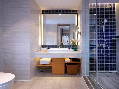 a bathroom with a tub and a sink and a shower at Kyriad Marvelous Hotel Chengdu Wuhou Shuangnan in Chengdu