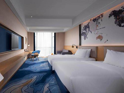 Ένα ή περισσότερα κρεβάτια σε δωμάτιο στο Kyriad Marvelous Hotel Foshan New City Lecong Town