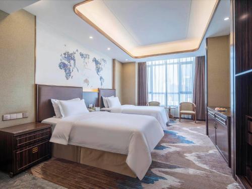 a hotel room with two beds and a large window at Kyriad Marvelous Hotel Weihai Railway Station in Weihai
