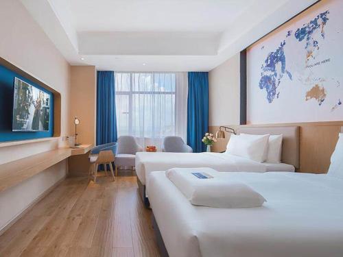 a hotel room with two beds and a map of the world at Kyriad Marvelous Hotel Huizhou Boluo Longxi in Boluo