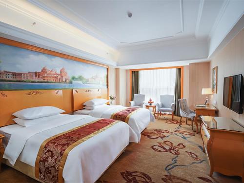 una camera d'albergo con due letti e una televisione di Vienna International Hotel Wuxi Huishan Yanqiao Metro Station a Wuxi